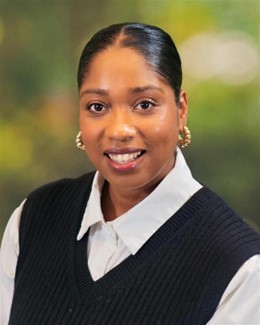 Bethesda-Chevy Chase_Jeanine Ali Professional headshot of Jeanine Ali smiling, wearing a white shirt and black sweater vest.